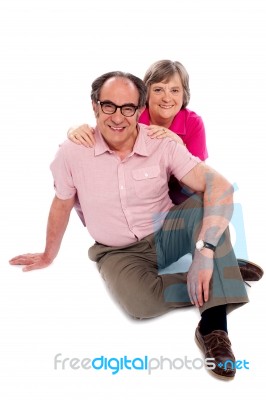 Senior Couple Sitting On Floor Stock Photo