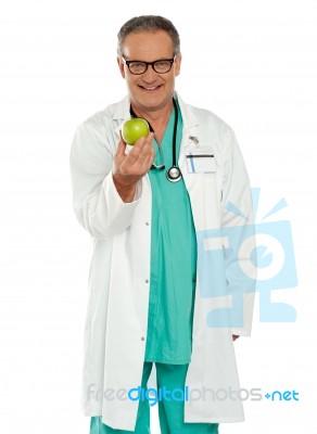 Senior Doctor holding Green Apple Stock Photo