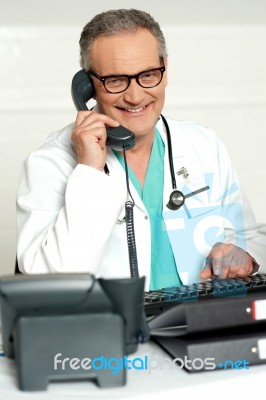 Senior Doctor Talking Over Phone Stock Photo