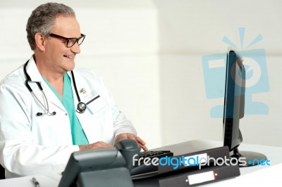 Senior Doctor Using Computer Stock Photo