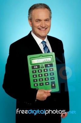 Senior Executive Posing With Big Green Calculator Stock Photo