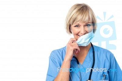 Senior Female Surgeon Removing Medical Mask Stock Photo