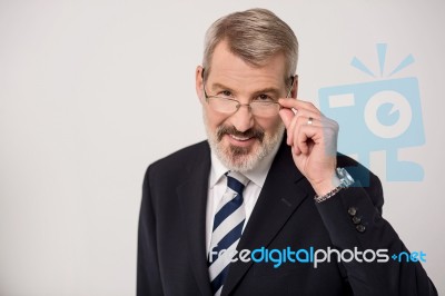 Senior Male Entrepreneur Adjusting Eyeglasses Stock Photo