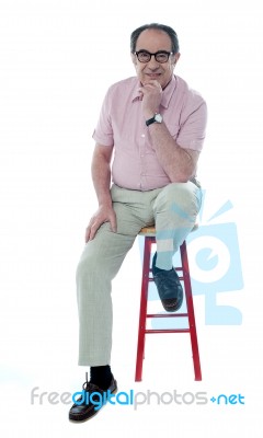 Senior Man Resting On Stool Stock Photo