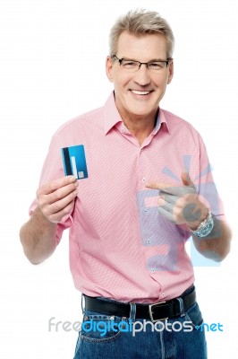 Senior Man Showing And Pointing Debit Card Stock Photo