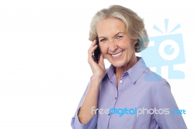 Senior Smiling Lady Attending Phone Call Stock Photo