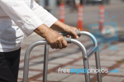 Senior Woman Using A Walker Cross Street Stock Photo