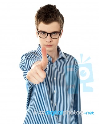 Serious Boy Gesturing Thumbs Up Stock Photo