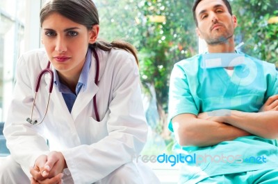 Serious Female Doctor With Colleague In Hospital Stock Photo