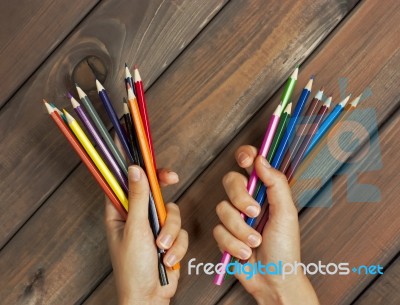 Set Of Colored Pencils In Female Hands On A Background Of Dark W… Stock Photo