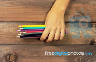 Set Of Colored Pencils In Female Hands On A Background Of Dark W… Stock Photo