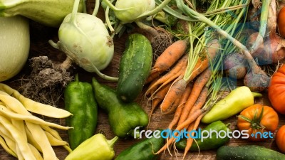 Several Vegetables On Wooden Chopping Board And Table Stock Photo