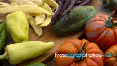 Several Vegetables On Wooden Chopping Board And Table Stock Photo