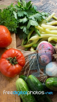 Several Vegetables On Wooden Chopping Board And Table Stock Photo