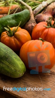 Several Vegetables On Wooden Chopping Board And Table Stock Photo