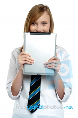 Shy Girl Hiding Her Face With A Tablet Device Stock Photo