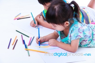 Sibling Lie On The Floor And Drawing On Paper, On White Backgrou… Stock Photo