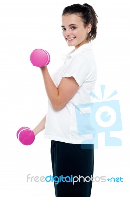 Side Pose Of Girl With Dumbbells Working Out Stock Photo