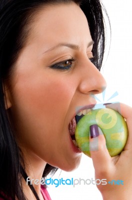 Side Pose Of Woman Eating Apple On White Background Stock Photo