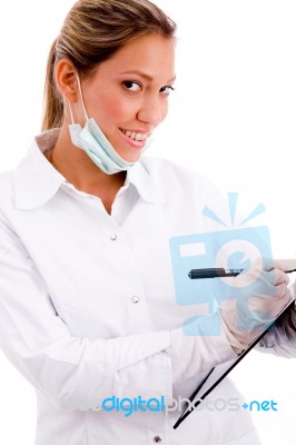 Side View Of Smiling Doctor With Writing Pad Stock Photo