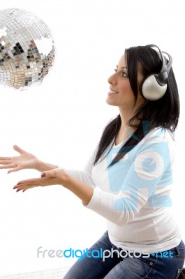 Side View Of Smiling Female Playing With Disco Mirror Ball Stock Photo