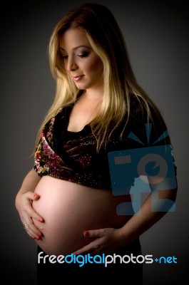 Side View Of Smiling Pregnant Woman Stock Photo