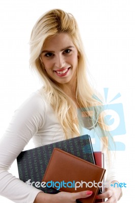 Side View Of Smiling Young Student Holding Books Stock Photo