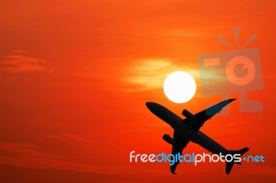 Silhouette Airplane And The Red Sky Stock Photo