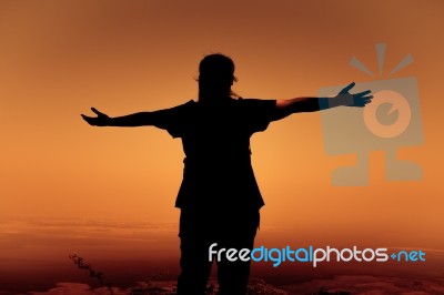 Silhouette Back View Of Woman Open Arms Under The Sunrise Stock Photo