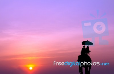 Silhouette Elephant With Tourist At Sunset Stock Photo