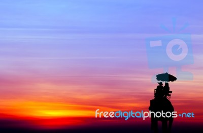 Silhouette Elephant With Tourist At Sunset Stock Photo