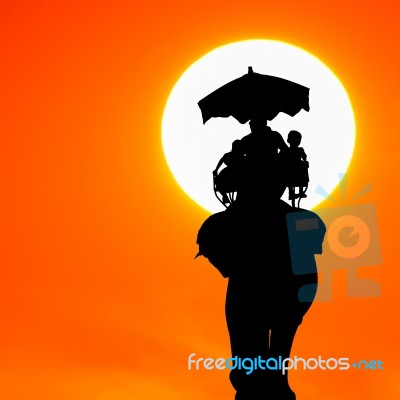 Silhouette Elephant With Tourist At Sunset Stock Photo