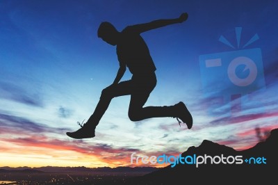 Silhouette Man Over The Cliff Stock Photo