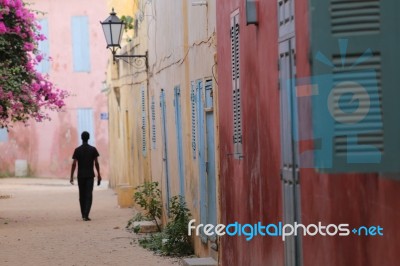 Silhouette Of A Man In A Colored Street Of Goree Island In Senegal Stock Photo