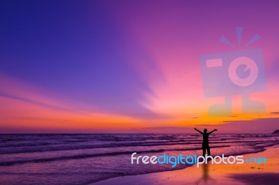 Silhouette Of A Man On The Beach At Twilight Stock Photo