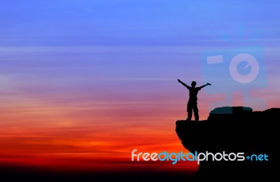 Silhouette Of A Man On The Rock At Sunset Stock Photo