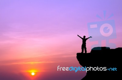 Silhouette Of A Man On The Rock At Sunset Stock Photo