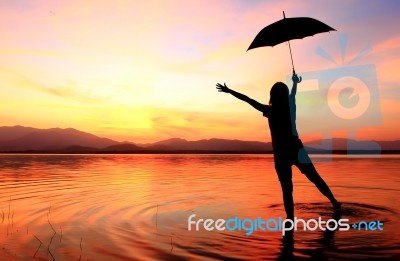 Silhouette Of Girl Against Sunset Stock Photo