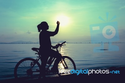 Silhouette Of Happy Female Celebrating With Arm Up Towards The S… Stock Photo