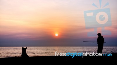 Silhouette Of Man Fishing Stock Photo