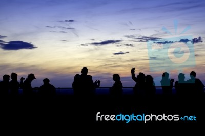 Silhouette Of Many People Watching Sunset Stock Photo