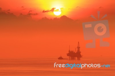 Silhouette Of Offshore Jack Up Drilling Rig And Boat Stock Photo