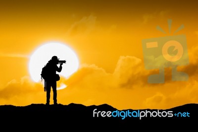 Silhouette Of Photographer With Camera At Sunset Stock Photo