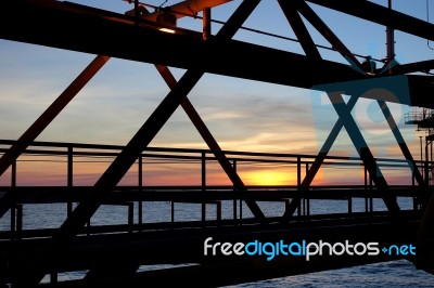 Silhouette Of Structure Of The Bridge In Sun Set At The Sea Stock Photo