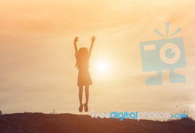 Silhouette Of Woman Jumping Against Beautiful Sky Background Stock Photo