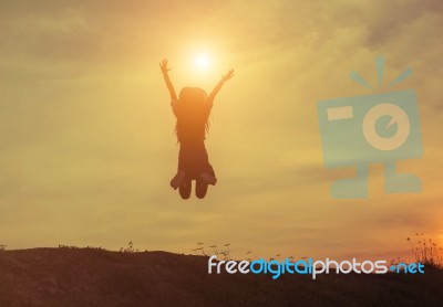 Silhouette Of Woman Jumping Against Beautiful Sky Background Stock Photo