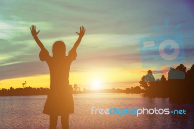 Silhouette Of Woman Praying Over Beautiful Sky Background Stock Photo