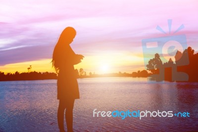 Silhouette Of Woman Praying Over Beautiful Sky Background Stock Photo