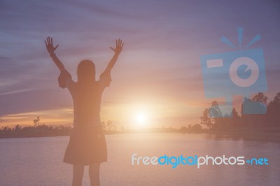 Silhouette Of Woman Praying Over Beautiful Sky Background Stock Photo