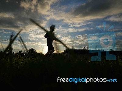 Silhouette  Running On Road At Sunrise Stock Photo